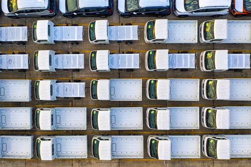 Rows of white fleet trucks seen from above