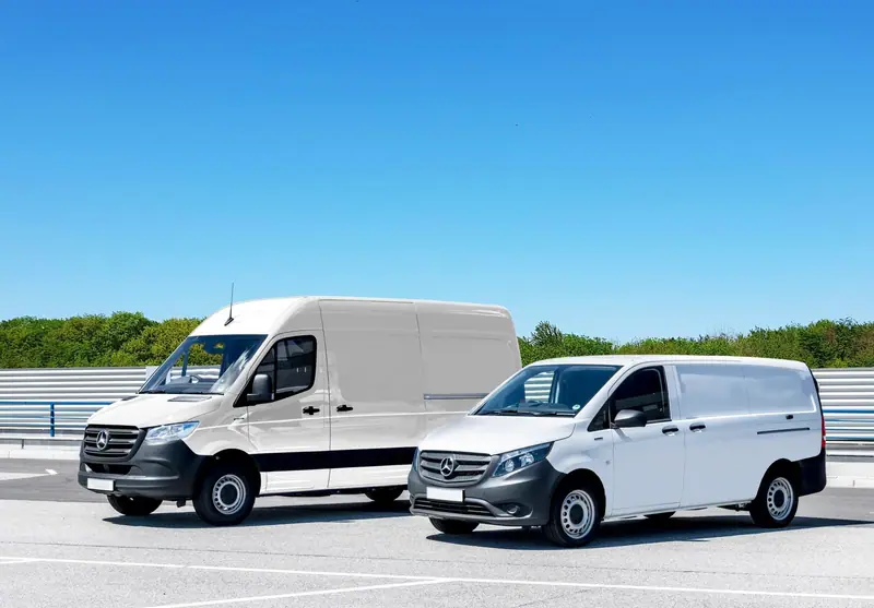 Two clean white work vans parked side by side