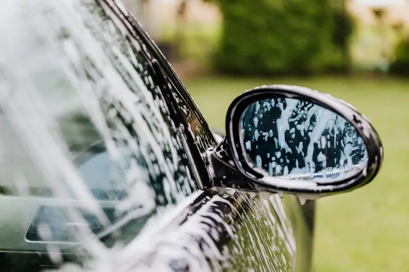 Soapy hand wash on a black side mirror