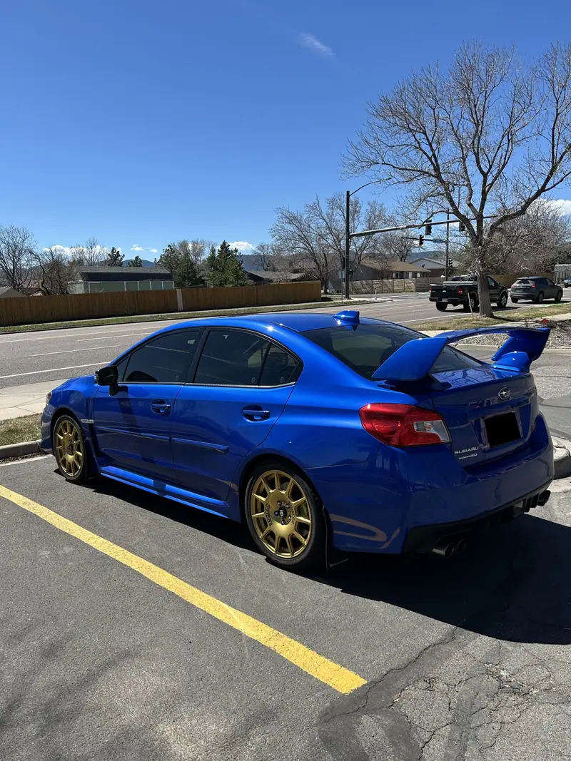 Blue Subaru WRX STI with gold wheels and freshly coated paint