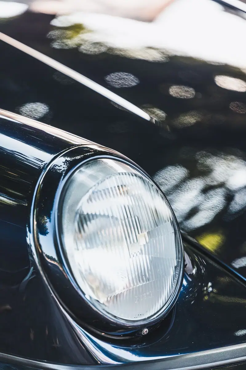 Clear round headlight on a black car