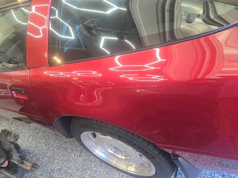 Red Corvette side panel with crisp reflections of hexagon lights