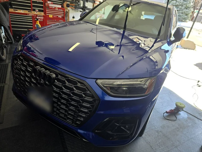 Blue Audi Q5 front end with deep gloss on the hood in a home garage