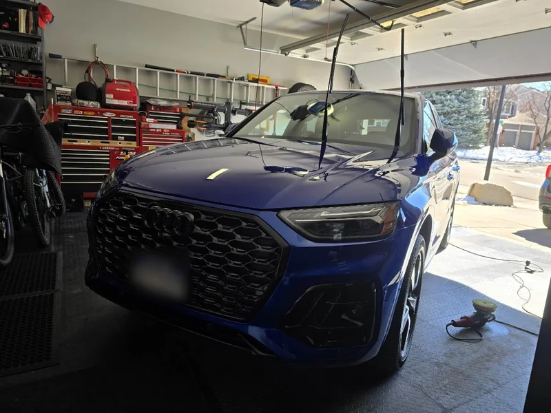 The same blue Audi Q5 parked in the garage after detailing