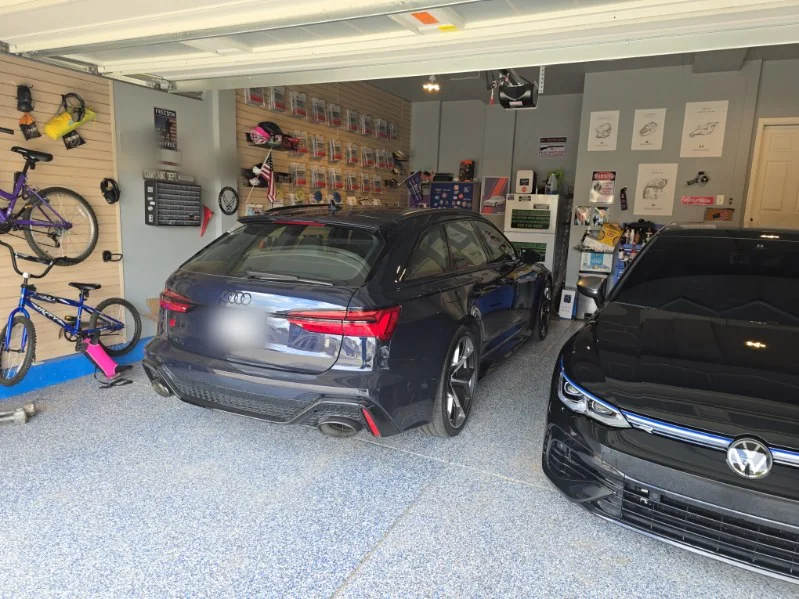 Audi RS6 Avant and a black VW Golf R side by side in a home garage