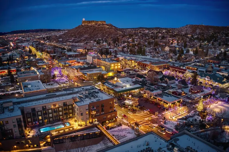 Downtown Castle Rock, Colorado at dusk with holiday lights and the lit star on the Rock