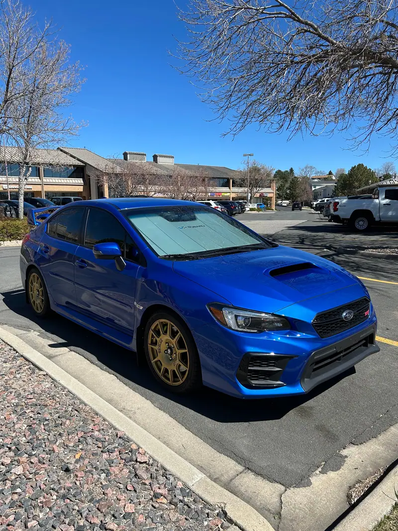 Blue Subaru WRX STI with gold wheels, from Patriot Ceramics job photos
